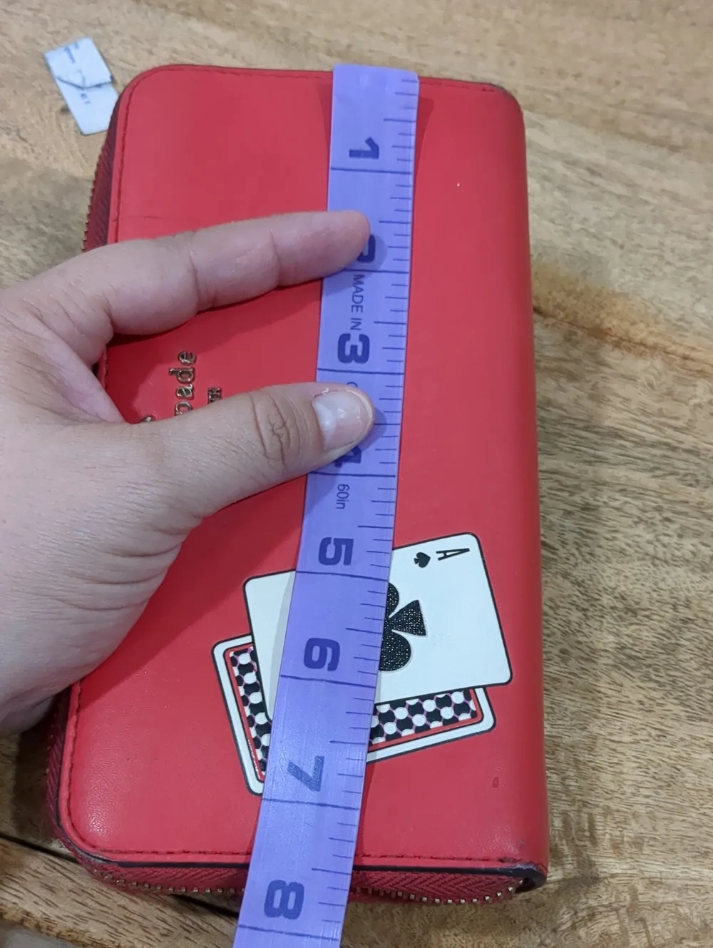 Kate Spade red zip-around wallet with Ace of Spades patch